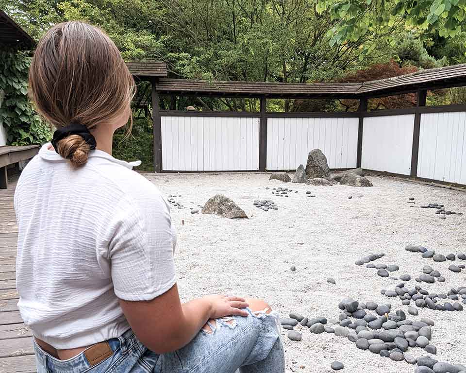 rachel hannah sitting inside of michigan state univesities zen garden in east lansing, michigan