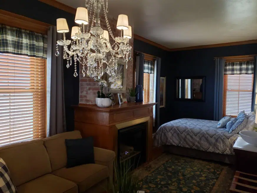 cottage styled room with brick fireplace and chandelier