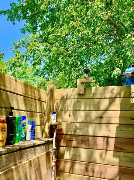 outdoor wooden walled shower with trees surrounding it
