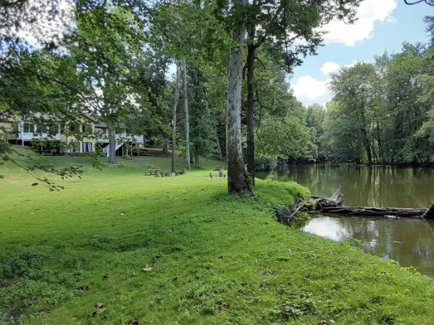 two story house on grassy riverfront property