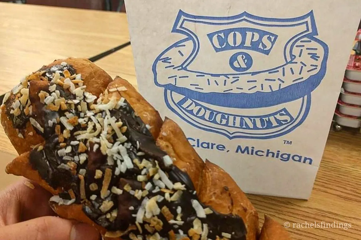 one of the best hidden gems in Michigan is cops and doughnuts. chocolate coconut long john is pictured