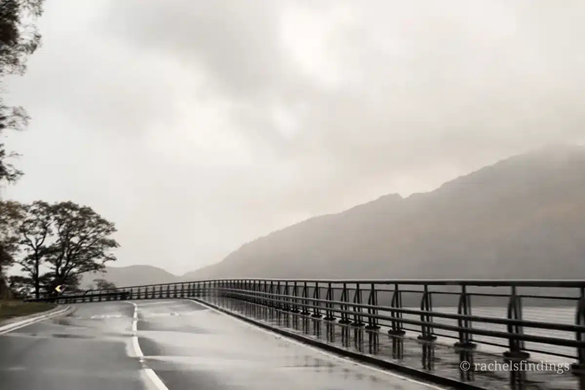foggy wet road necxt to a loch