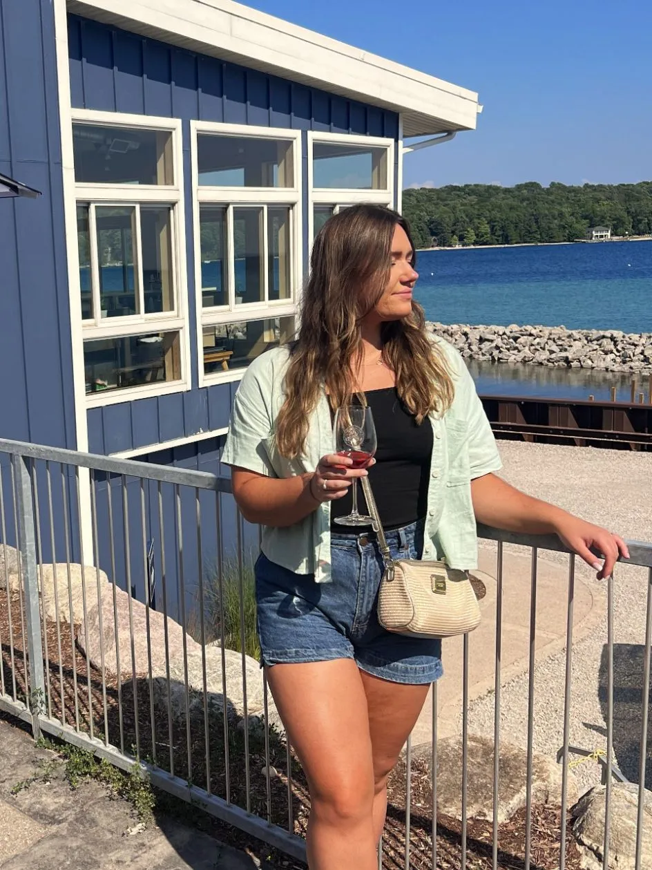 girl with wine in front of leelanau cellers winery
