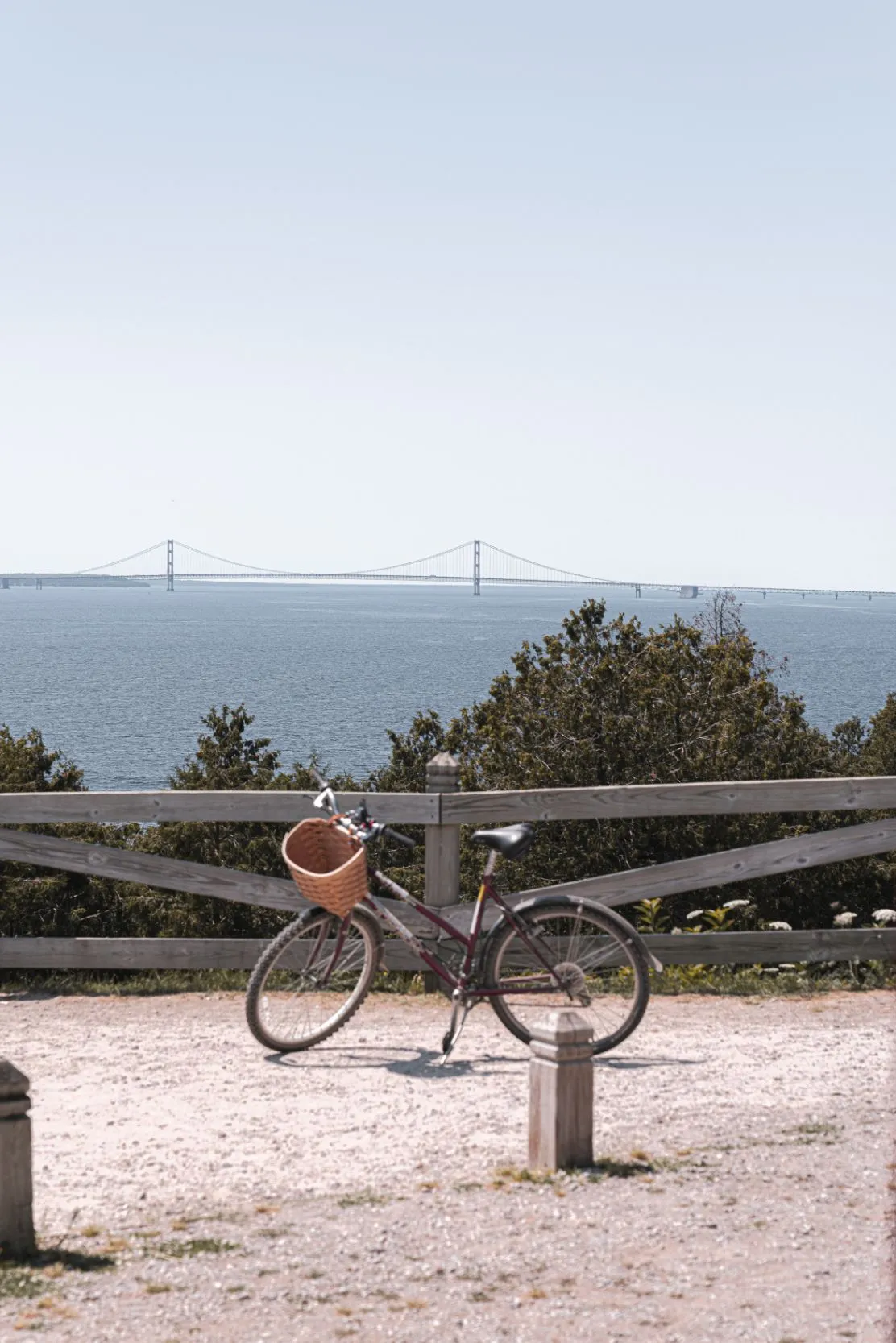 bike posed by waters edge on mackinac island with mackinac bridge in distance
