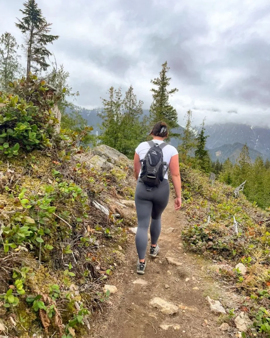 girl on dirt part of haybrook ridge trail with mountains index wa