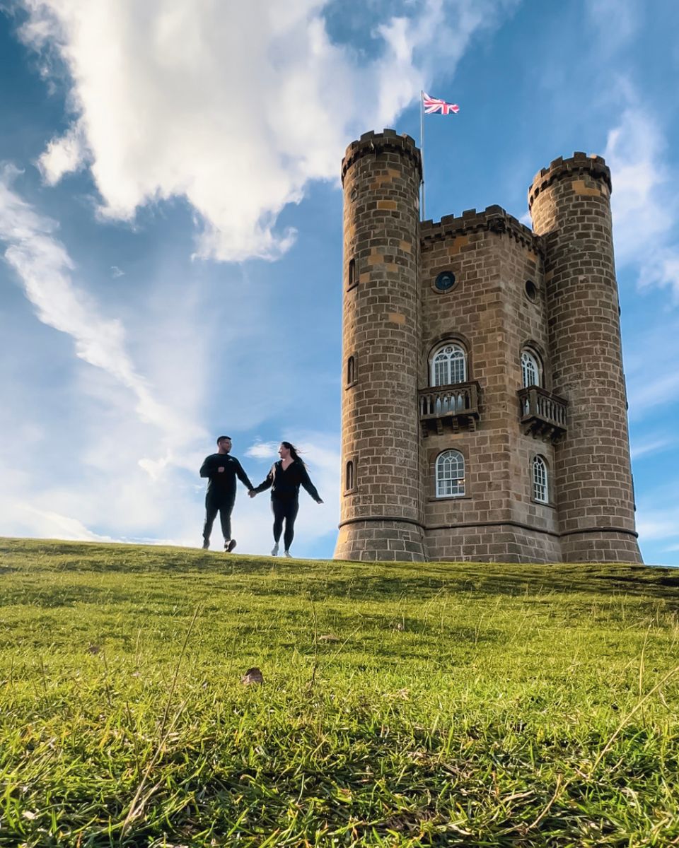couple running down hill at broadway tower