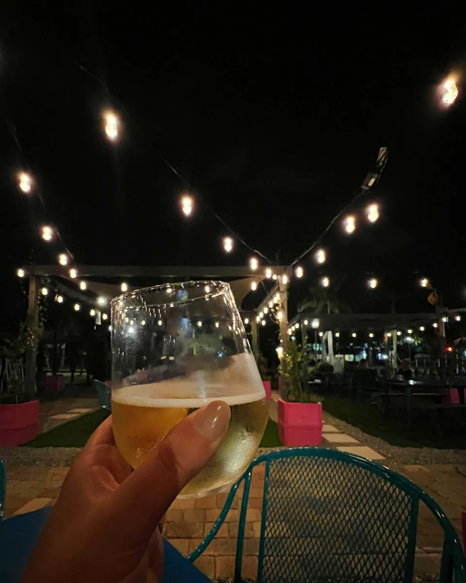 holding wine glass at night with string lights lolitas wine bar st pete