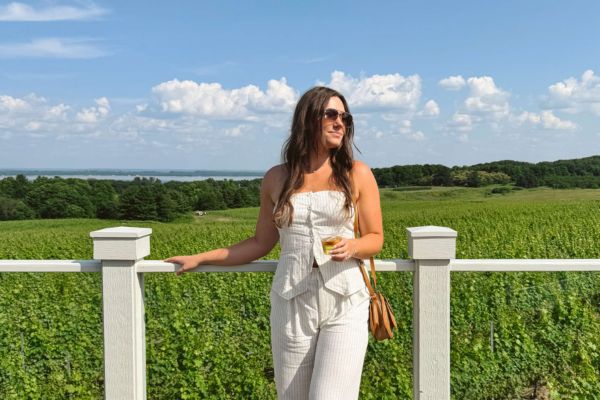 girl wearing white standing on brys estate balcony overlooking lake and vineyards